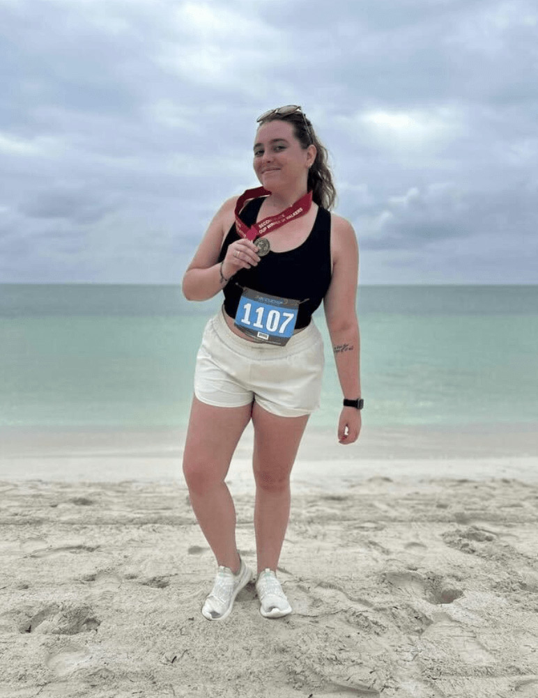 Woman holding a medal at the beach