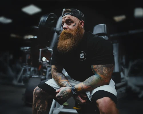 Kevin in the gym sitting on a bench press.